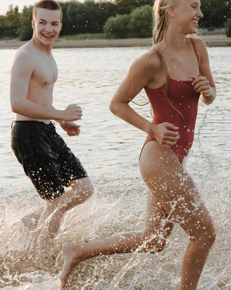 Older children running at the beach after benefiting from a Well-Child Check
